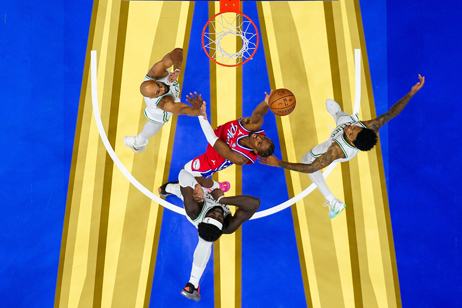 Philadelphia 76ers' Tyrese Maxey, center, puts up the shot as he splits between the Boston Celtics defenders during the first half of an NBA Cup basketball game
