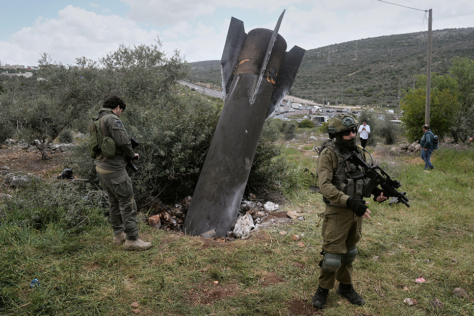 Israeli soldiers secure the site where an Iranian missile wreckage landed in the West Bank village of Kifl Haris